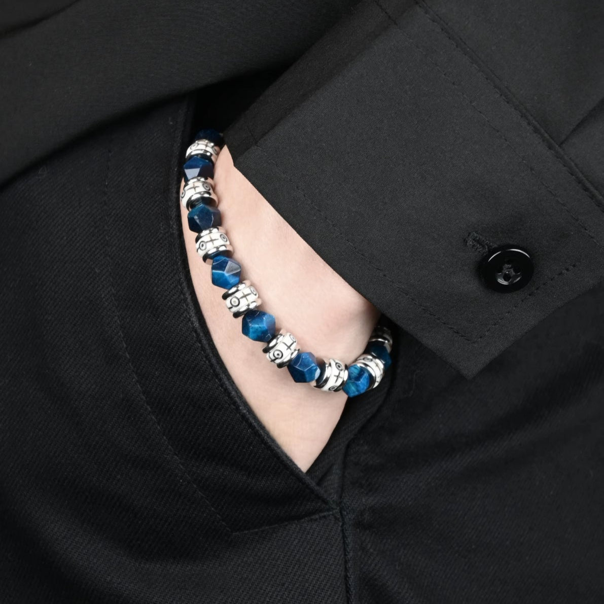Close-up detail of beaded bracelets made with blue tiger eye and ox bone.