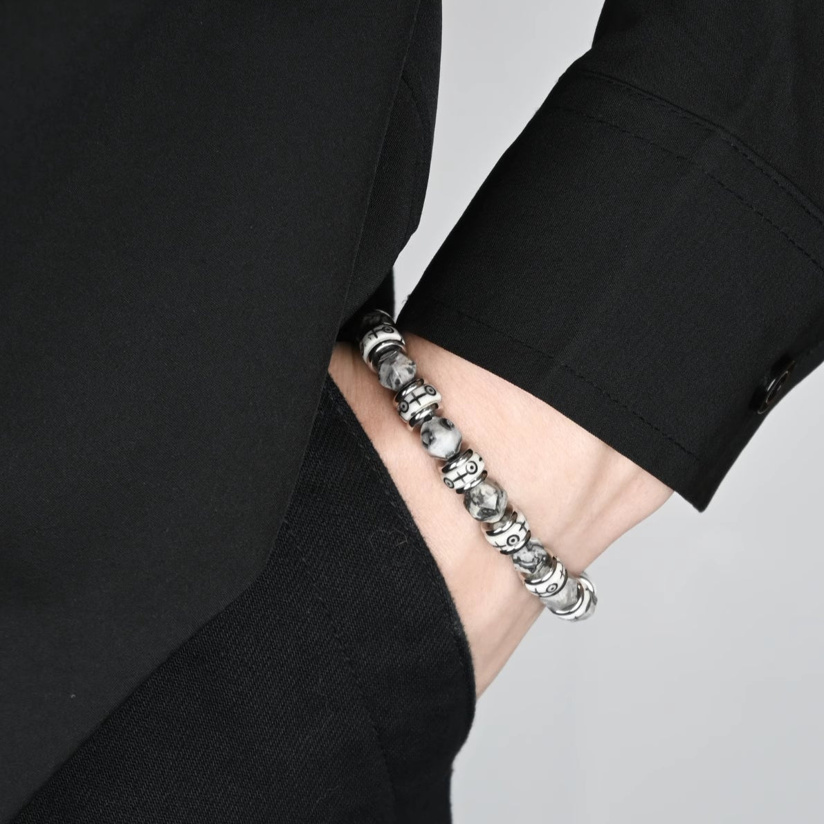 Mens beaded bracelet displayed with natural elements representing grounding energy