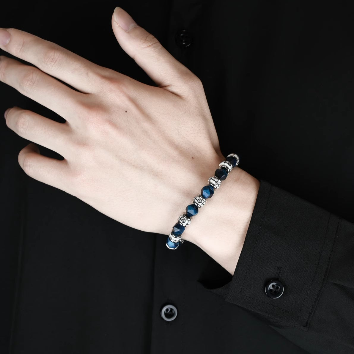 Layered styling of blue tiger eye beaded bracelets for men.