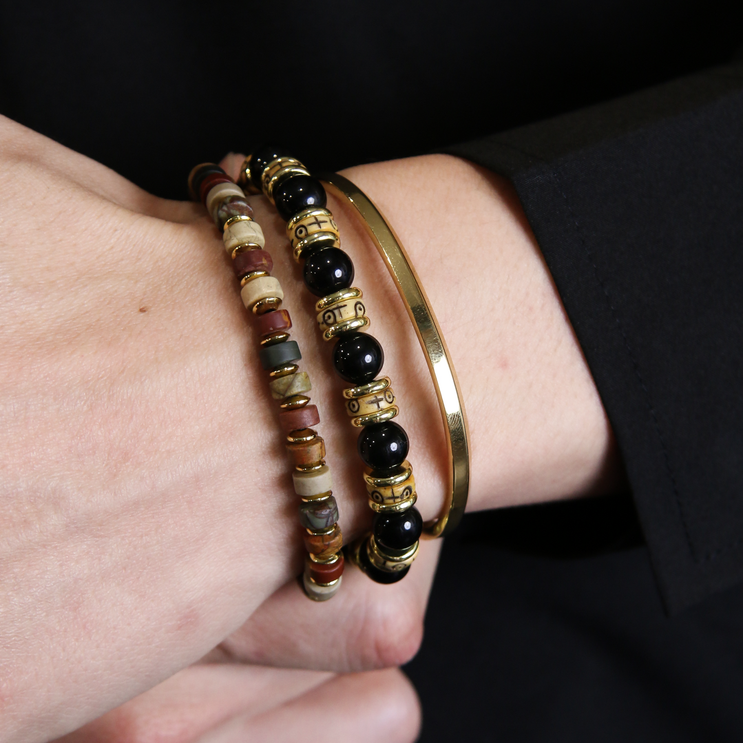 Stack of mens beaded bracelets including Picasso Stone